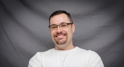 Man standing smiling with arms crossed